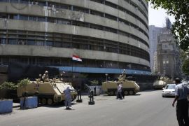 Egyptian military soldiers stand guard atop armored personnel carriers at Maspero, an Egypt's state tv and radio station, not far from Tahrir Square in Cairo Saturday, July 6, 2013. Egyptians were on edge Saturday morning after supporters and opponents of ousted President Mohammed Morsi fought overnight street battles that left at least 30 dead across the increasingly divided country.