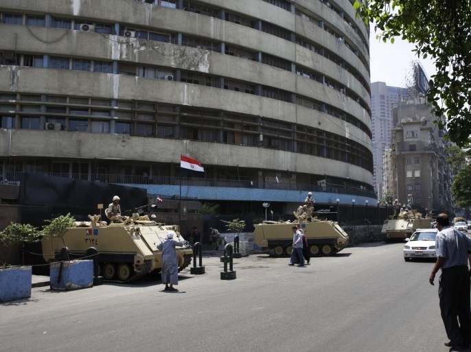 Egyptian military soldiers stand guard atop armored personnel carriers at Maspero, an Egypt's state tv and radio station, not far from Tahrir Square in Cairo Saturday, July 6, 2013. Egyptians were on edge Saturday morning after supporters and opponents of ousted President Mohammed Morsi fought overnight street battles that left at least 30 dead across the increasingly divided country.