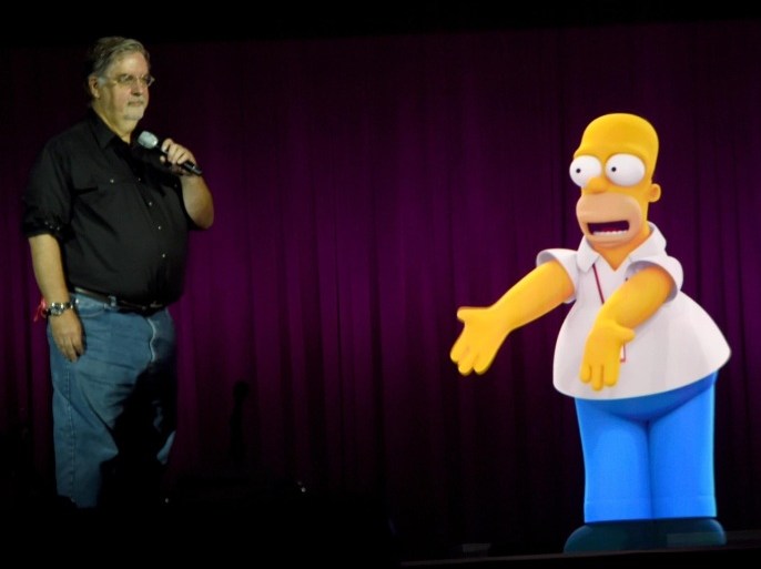 SAN DIEGO, CA - JULY 26: Writer/producer Matt Groening interacts with a projection of Homer Simpson during FOX's 'The Simpsons' panel during Comic-Con International 2014 at the San Diego Convention Center on July 26, 2014 in San Diego, California.