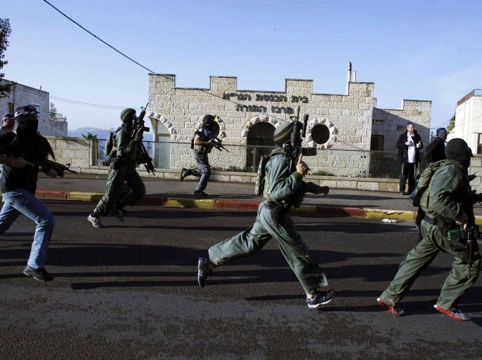 Israeli security personnel run next to a synagogue, where a suspected Palestinian attack took place, in Jerusalem, November 18, 2014. Up to five people were killed on Tuesday in the attack by two men armed with axes and knives, Israeli media reported. REUTERS/Ronen Zvulun (JERUSALEM - Tags: POLITICS CIVIL UNREST TPX IMAGES OF THE DAY)