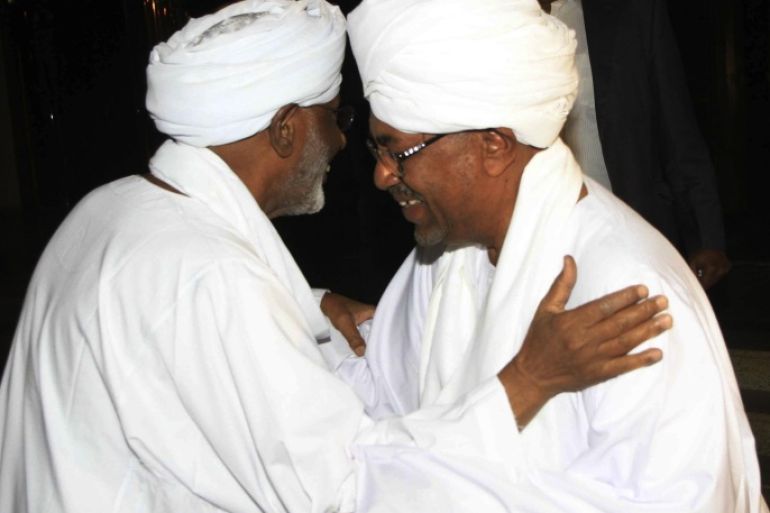 Sudan's President Omar al-Bashir (R) welcomes Islamic Opposition Leader Hassan Al Turabi during an official meeting after more than 10 years, in Khartoum March 14, 2014. REUTERS/Stringer (SUDAN - Tags: POLITICS)