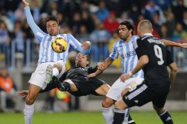 Real Madrid's Portuguses striker Cristiano Ronaldo (2L) tries to score next to defenders Weligton (L) and Sergio Sanchez (2R) of Malaga FC during their Primera Division soccer match played at La Rosaleda stadium in Malaga, Andalusia, Spain on 29 November 2014.