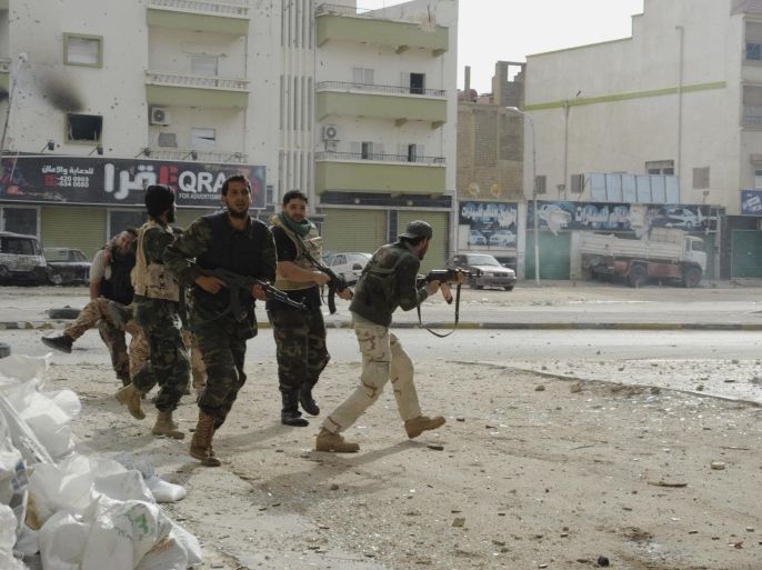 Libyan military soldiers run to take cover during clashes with Islamic extremist militias in Benghazi, Libya, Thursday, Oct. 30, 2014. Government troops entered central Benghazi Wednesday after nearly 10 days of fighting Islamic extremist militias, a military spokesman said, in violence that killed dozens of people and forced hundreds of families to flee. (AP Photo/Mohammed el-Sheikhy)