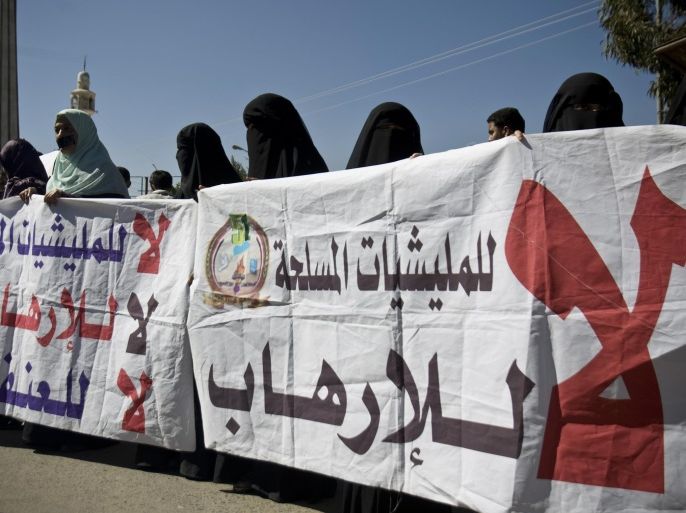 Yemeni protesters hold banners with Arabic writing that reads, "No to militia, No to terrorism, No to violence," to protest against the Shiite insurgency during a rally in Sanaa, Yemen, Saturday, Nov. 22, 2014. (AP Photo/Hani Mohammed)