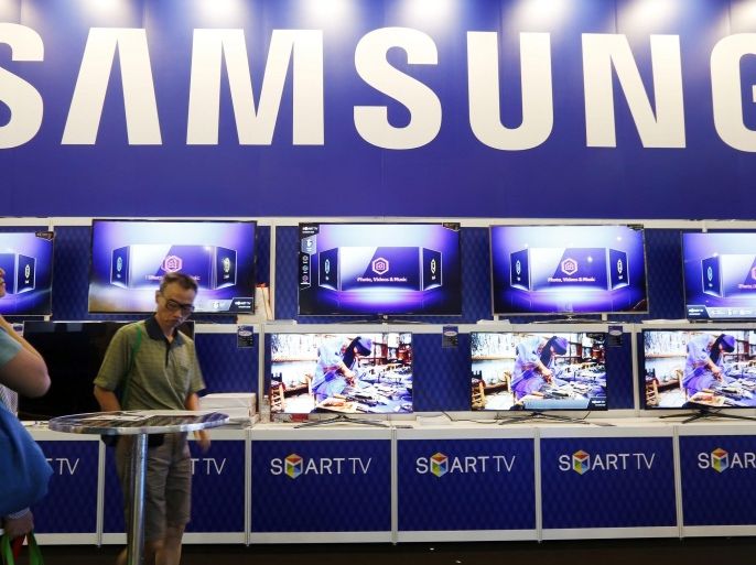 (FILE) A file photo dated 28 November 2013 showing visitors viewing Samsung Smart TVs on display at SITEC 2013, IT & Consumer Electronics show in Singapore. Samsung Electronics saw net profit drop 48.7 per cent from a year earlier on sagging sales of its high-end smartphones, the company said 30 October 2014. Net profit was down to 4.22 trillion won (4.01 billion dollars) in the third quarter, it said. Turnover was down 19.6 per cent to 47.45 trillion won in the same period, as the company faced increasing competition from Chinese-made, cheaper smartphones. Operating profit for the company was down 60 per cent to 4.1 trillion won for the quarter, although this was in part due to the record high of 10.1 trillion won a year earlier.