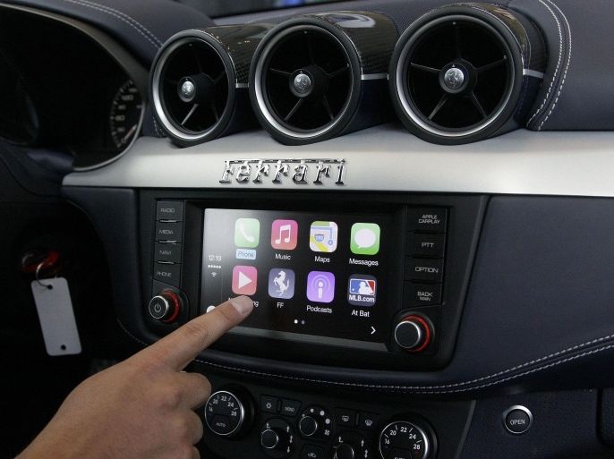 Stephen Chick with Apple gives a demonstration of CarPlay in a Ferrari at the Apple Worldwide Developers Conference in San Francisco, Monday, June 2, 2014. (AP Photo/Jeff Chiu)