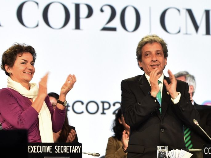 UNFCCC Executive Secretary Christiana Figueres and COP20 President and Peruvian Minister of Environment Manuel Pulgar celebrate the approval of the proposed compromise document handed out during the marathon UN talks in order to meet the final goal of the UN COP20 and CMP10 climate change conferences in Lima on December 14, 2014. UN members on Sunday adopted a format for national pledges to cut greenhouse gases, the heart of a planned pact to defeat climate change. AFP PHOTO/CRIS BOURONCLE