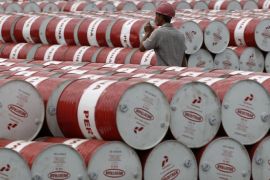 A worker walks in between oil barrels at Pertamina's storage depot in Jakarta in this January 26, 2011 file photo. To match Special Report CHINA-CORRUPTION/INDONESIA REUTERS/Supri/Files (INDONESIA - Tags: ENERGY BUSINESS)