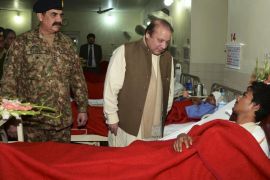 In this picture released by the Inter Services Public Relations, Pakistan's Prime Minister Nawaz Sharif, center, talks to an injured student, a victim of Tuesday's school attack, as Army Chief Gen. Raheel Sharif watches them during their visit to a military hospital in Peshawar, Pakistan, Wednesday, Dec. 17, 2014. The Taliban massacre that killed at least 148 people, mostly children, at a military-run school in northwestern Pakistan left a scene of heart-wrenching devastation, pools of blood and young lives snuffed out as the nation mourned and mass funerals for the victims got underway Wednesday. (AP Photo/Inter Services Public Relations)