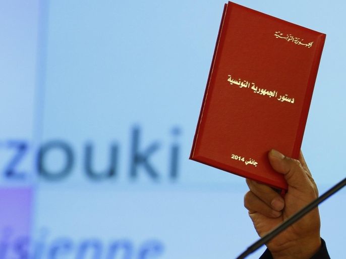 Tunisia President Moncef Markouzi holds a copy of the Tunisian new constitution during his address to the 25th session of the Human Rights Council at the United Nations in Geneva March 3, 2014. REUTERS/Denis Balibouse (SWITZERLAND - Tags: POLITICS)