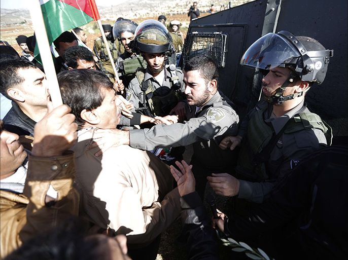 An Israeli border guard grabs Palestinian official Ziad Abu Ein (L), in charge of the issue of Israeli settlements for the Palestinian Authority, during a demonstration in the village of Turmus Aya near Ramallah, on December 10, 2014. Abu Ein died after being beaten by Israeli forces during a protest march in the West Bank, medical and security sources told AFP. AFP PHOTO / ABBAS MOMANI