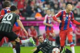 MUNICH, GERMANY - DECEMBER 16: Arjen Robben (R) of Muenchen challenges Oliver Sorg (C) of Freiburg during the Bundesliga match between FC Bayern Muenchen and SC Freiburg at Allianz Arena on December 16, 2014 in Munich, Germany.