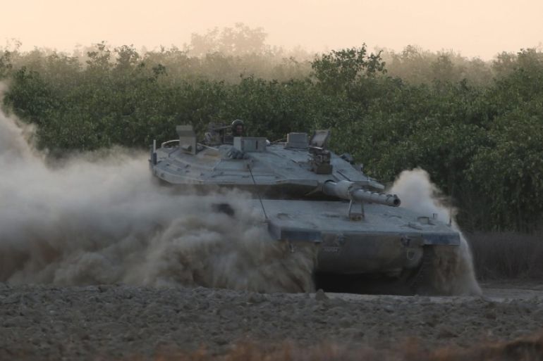 An Israeli Merkava tank takes position at the border with the Gaza Strip (in the background), southern Israel, 07 July 2014. Israeli military confirmed that ground troops were moving southwards towards the border area with the Gaza Strip, from which rockets have been fired at Israel.
