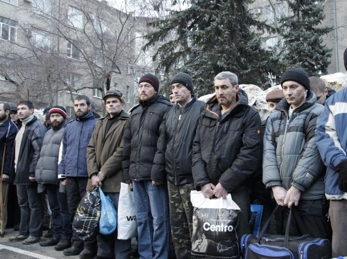 Ukrainians prepare for an exchange of prisoners in front of a city prison in Donetsk in eastern Ukraine, Friday Dec. 26, 2014. Ukrainian authorities and pro-Russia rebels exchanged nearly 370 prisoners Friday, the biggest one-time prisoners swap since the pro-Russian insurgency flared up in eastern Ukraine in April and a major step toward easing hostilities in eastern Ukraine. (AP Photo/Alexander Ermochenko)