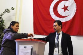 A Tunisian woman casts her ballot in the Tunisian consulate in Paris on December 20, 2014, as she votes for the second round of the Presidential election. Capping off four years of a sometimes chaotic transition, the vote is the first time Tunisians are freely electing their president since independence from France in 1956. AFP PHOTO / DOMINIQUE