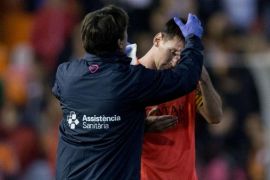 VALENCIA, SPAIN - NOVEMBER 30: A medical assistant treat Lionel Messi of FC Barcelona after being blown with a bottle after the La Liga match between Valencia CF and FC Barcelona at Estadi de Mestalla on November 30, 2014 in Valencia, Spain.