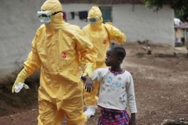 FOR USE AS DESIRED, YEAR END PHOTOS - FILE - Nine-year-old Nowa Paye is taken to an ambulance after showing signs of the Ebola infection in the village of Freeman Reserve, about 30 miles north of Monrovia, Liberia,Tuesday Sept. 30, 2014. (AP Photo/Jerome Delay, File)