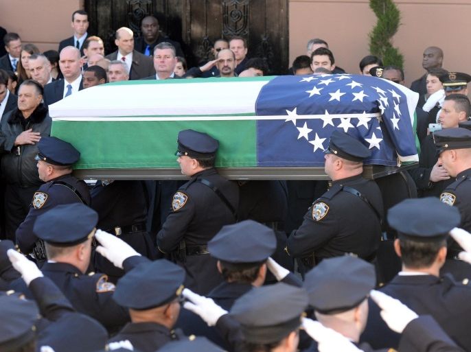 The casket of New York Police Officer Rafael Ramos is carried out of Christ Tabernacle church on December 27, 2014 in New York. Thousands of people, including US Vice President Joe Biden, attended the funeral Saturday for Ramos, one of two New York officers shot dead in apparent revenge for recent police killings of unarmed black men. Ramos was shot alongside his partner Wenjian Liu on December 20 on the heels of nationwide protests accusing police of racism and using excessive force against black people.  AFP PHOTO/DON EMMERT