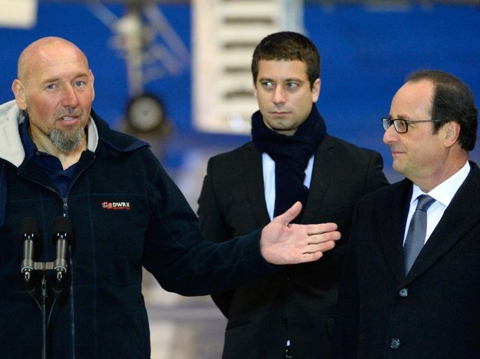Serge Lazarevic (L), France's last remaining hostage, addresses the media as French President Francois Hollande (R) and Clement Verdon, the son of French executed hostage Philippe Verdon, look on, after Lazarevic landed in a French Republic plane at the Villacoublay military base near Paris on December 10, 2014. Lazarevic, who was snatched by armed men in Mali on November 24, 2011, arrived home on December 10 after three years at the hands of Islamist militants, and was greeted by French President Francois Hollande. AFP PHOTO / BERTRAND GUAY