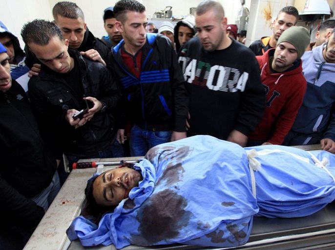 RAMALLAH, WEST BANK - DECEMBER 16: The dead body of Palestinian Mahmoud Adwan shot in the head during clashes with Israeli forces in the Qalandia refugee camp near the West Bank city of Ramallah on Tuesday, is carried to Palestine Medical Complex (PMC) in Ramallah on December 16,2014.