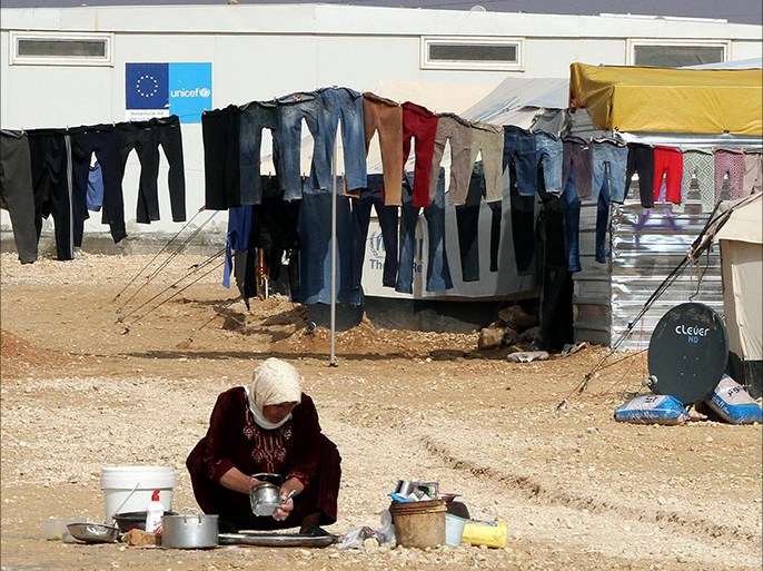 epa04530455 A Syrian refugee woman washes dishes in front of her tent at the Zattari refugee camp near Mafraq city, Jordan, 15 December 2014. The World Food Programme (WFP) said on 09 December it will be able to resume its food