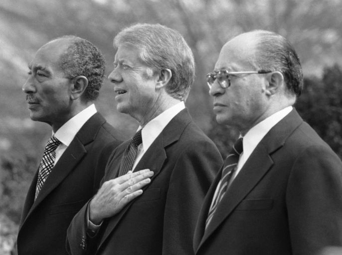 FILE - In this Monday, Feb. 24, 1979 file photo, Egyptian President Anwar Sadat, left, U.S. President Jimmy Carter, center, and Israeli Prime Minister Menachem Begin, stand at attention as the national anthems of their respective countries are played on the north lawn of the White House in Washington. The Central Intelligence Agency has declassified 1,400 pages of intelligence surrounding the Camp David Accords, the historic peace treaty negotiated in 1978 by then-President Jimmy Carter with the leaders of Israel and Egypt, Wednesday, Nov. 13, 2013.