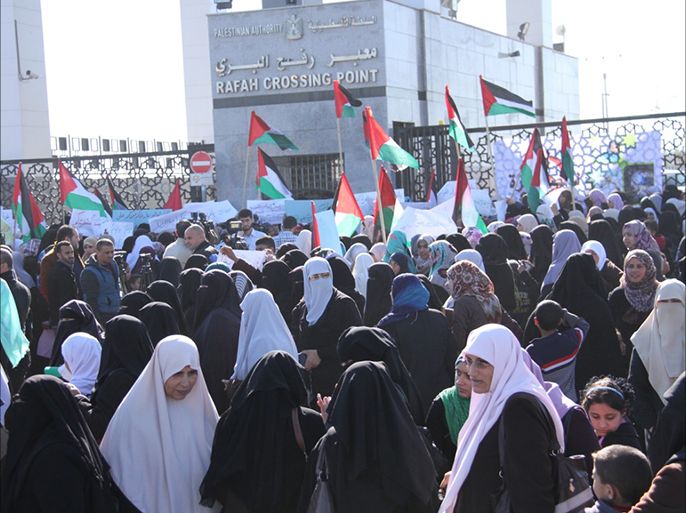 عدد من المشاركات ضمن مبادرة فلسطينيات ضد الحصار يرفعن لافتات اثناء الاعتصام على معبر رفح.