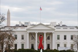 A giant red ribbon is affixed on the front of the White House on World Aids Day, on December 1, 2014 in Washington, DC. AFP PHOTO/Mandel NGAN