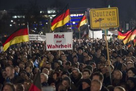 Supporters of the PEGIDA movement, "Patriotische Europaeer Gegen die Islamisierung des Abendlandes," which translates to "Patriotic Europeans Against the Islamification of the Occident," take part in a rally in Dresden, Eastern Germany on December 15, 2014. More than 10,000 people demonstrated against "criminal asylum seekers" and the "Islamisation" of the country, in the latest show of strength of a growing far-right populist movement, according to police. AFP PHOTO / JENS SCHLUETER
