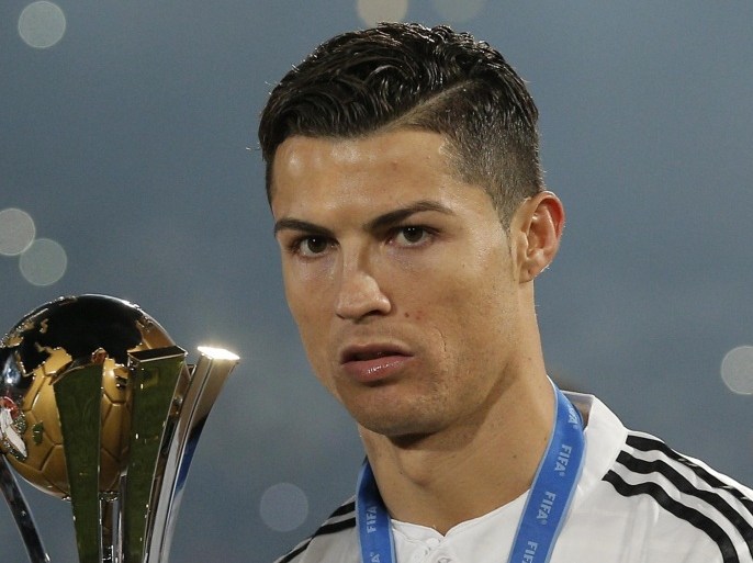 Real Madrid’s Cristiano Ronaldo poses with the trophy after winning the final soccer match between Real Madrid and San Lorenzo at the Club World Cup soccer tournament in Marrakech, Morocco, Saturday, Dec. 20, 2014. (AP Photo/Christophe Ena)