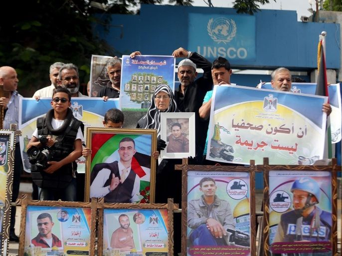 GAZA CITY, GAZA - SEPTEMBER 25: Relatives of journalists killed by recent Israeli offensive protest Israel demading it to be tried in International Criminal Court in front of United Nations building as they hold pictures of killed journalist in Gaza City, Gaza on September 25, 2014.