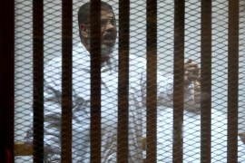 CAIRO, EGYPT - DECEMBER 6: Mohamed Morsi stands inside a glass defendant's cage during his trial at Police Academy in the east of Cairo, Egypt, on December 6, 2014. Morsi and his 35 other co-defendants are accused of being spy.