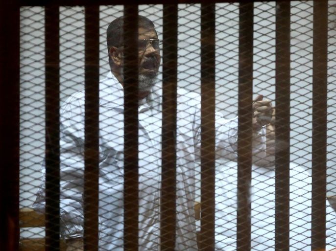CAIRO, EGYPT - DECEMBER 6: Mohamed Morsi stands inside a glass defendant's cage during his trial at Police Academy in the east of Cairo, Egypt, on December 6, 2014. Morsi and his 35 other co-defendants are accused of being spy.