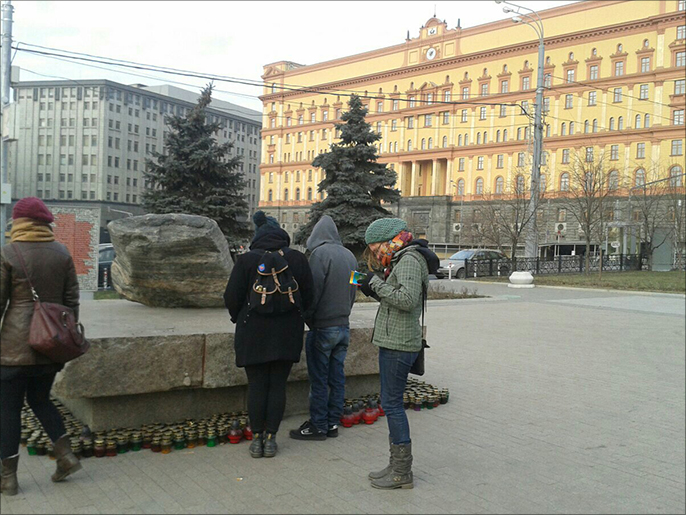 ‪‬ مواطنون روس يزورون نصبا تذكاريا لضحايا القمع السياسي في العهد السوفياتي(الجزيرة)