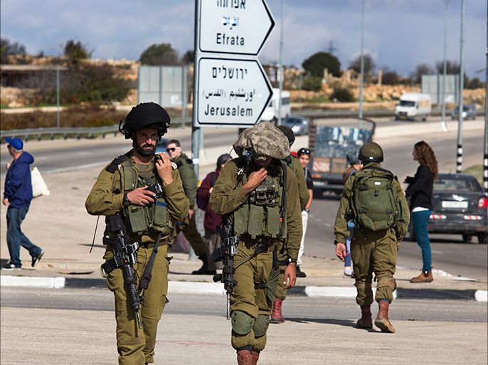 epa04510691 Israeli soldiers at the Gush Etzion exchange where an alleged stabbing attack by a Palestinian woman on an Israeli soldier took place outside the Jewish settlement of Efrat in the West Bank, south of Jerusalem, 01 December 2014. According to media reports, the Palestinian woman from the nearby village of Fajar was shot and is in serious condition in an Israeli hospital. EPA/JIM HOLLANDER