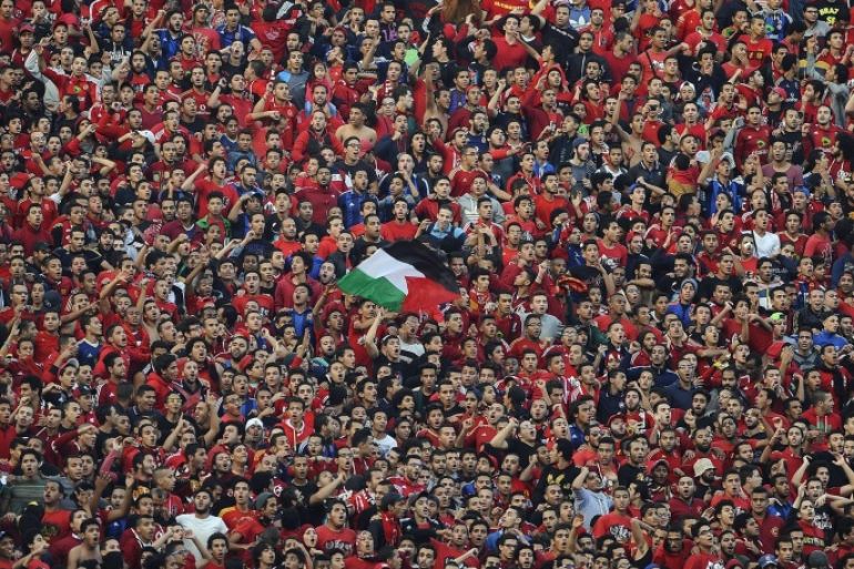 CAIRO, EGYPT - DECEMBER 06 : Fans of the Egypt's Al-Ahly chant slogans before the second leg of the CAF Confederation Cup final football match between Egypt's Al-Ahly and Ivory Coast's Sewe Sport at the Cairo Stadium in Cairo, Egypt on December 06, 2014.
