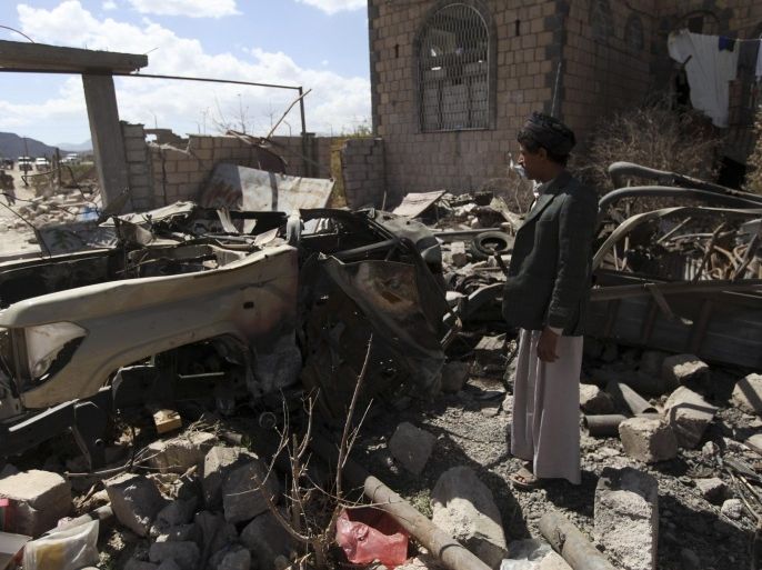 A Shi'ite Houthi man looks at debris next to the wreckage of a car used by an al Qaeda suicide bomber during recent fighting in Rada November 22, 2014. REUTERS/Mohamed al-Sayaghi (YEMEN - Tags: CIVIL UNREST CONFLICT)