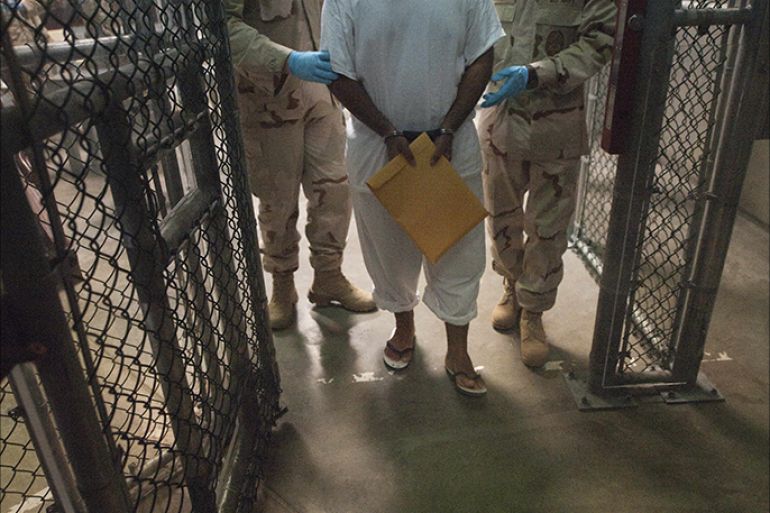 This March 30, 2010 file photo shows US military guards as they move a detainee inside Camp VI at Guantanamo Bay, Cuba.