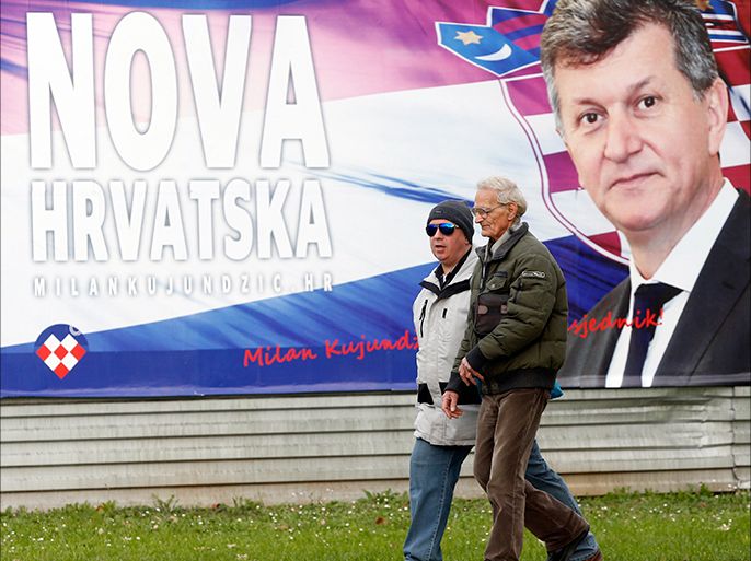 epa04538904 Two men walk past an election poster of independent presidential candidate Milan Kujundzic with his slogan reading 'New Croatia' in downtown Zagreb, Croatia, 23 December 2014. Croatina President Josipovic is running for re-elections at the presidential elections scheduled to be held on 28 December 2014. EPA/ANTONIO BAT