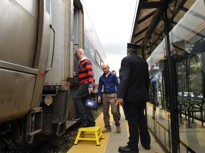 In a Friday, Sept. 12, 2014 photo, passengers board an Amtrak train bound for Chicago at the Royal Oak Station in Royal Oak, Mich. The Michigan Senate has cleared the way for the state to upgrade the speed and comfort of Amtrak services between Detroit and Chicago. Transportation officials plan to buy two sets of cars and engines to allow trains to reach 110 mph and cut transit time by up to two hours in coming years. (AP Photo/Detroit News, John T. Greilick) DETROIT FREE PRESS OUT; HUFFINGTON POST OUT