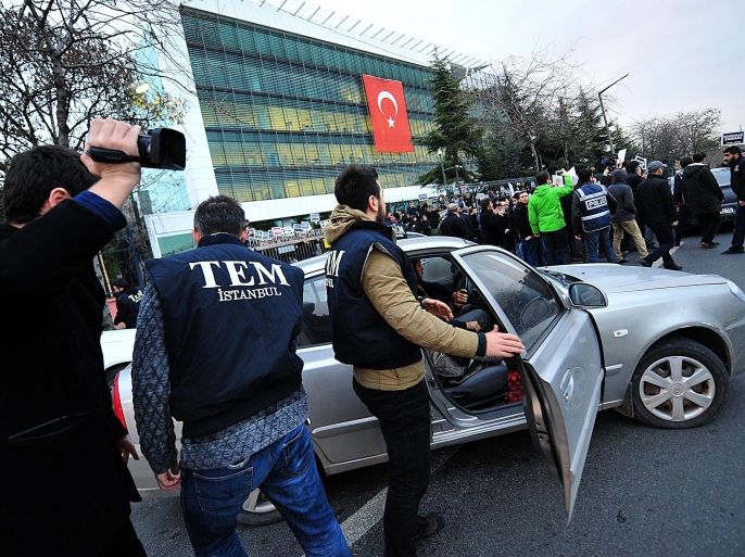 Turkish counter terror police arrive at the headquarters of Zaman newspaper as protesters gather to demonstrate against their raid in Istanbul on December 14, 2014. Turkish police launched a sweeping operation to arrest supporters of President Recep Tayyip Erdogan's rival, US-exiled imam Fethullah Gulen, including a raid on the offices of the Zaman daily, which is close to the cleric. A huge crowd gathered outside the offices of Zaman on the outskirts of Istanbul, creating a small stampede and forcing the police to leave the building without detaining any newspaper employees. AFP PHOTO/OZAN KOSE