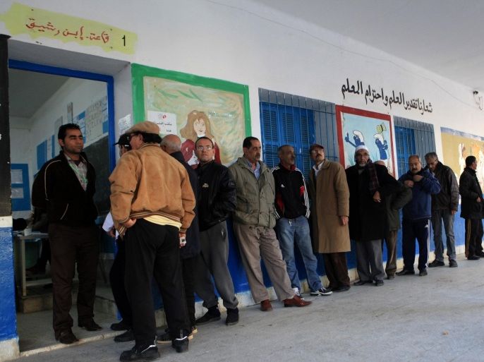 BEN AROUS, TUNISIA - DECEMBER 21: Tunisians wait in line to cast their ballots to elect the country's next president in a runoff vote at Nehic Elkrivan school in Ben Arous, Tunisia on December 21, 2014. Nearly 5.3 million Tunisian voters are eligible to cast ballot in Sunday's election, which is billed as the final round of the country's first democratic presidential vote.