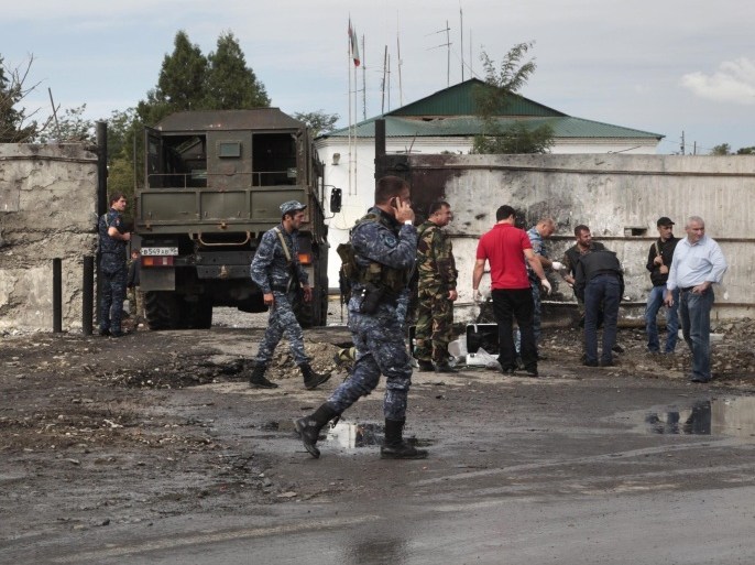 Chechen Police officers secure the area after a bomb blast at the police station in Sernovodsk, Chechnya, southern Russia, on Monday, Sept. 16, 2013. Russian news reports say three policemen have been killed and four injured by the suicide car bombing in Chechnya. (AP Photo/Musa Sadulayev)