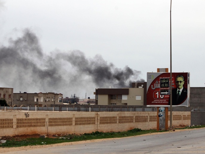 ‪دخان يتصاعد من موقع تعرض للقصف في مدينة بنغازي‬ (غيتي إيميجز)