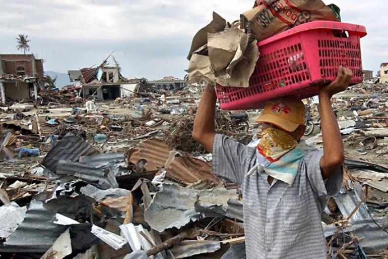 An Indonesian man carries some belongings from his damaged shop in Banda Aceh, 31 December 2004, six days after the powerful earthquake and resulting tsunami hit the area. The death toll in Indonesia from the massive earthquake and tsunami that has devastated Asia could reach up to 100,000, the health minister said 31 December. AFP PHOTO/CHOO YOUN-KONG