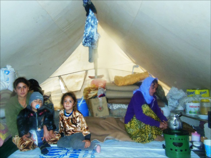 ‪نارين إلياس داخل خيمتها مع أطفالها‬ (الجزيرة)