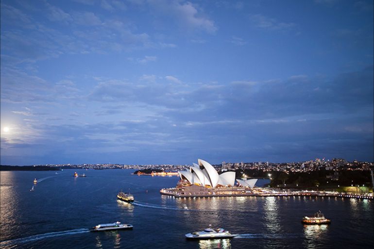 epa04436927 The moon rises behind the Opera House in Sydney, Australia, 08 October 2014. EPA