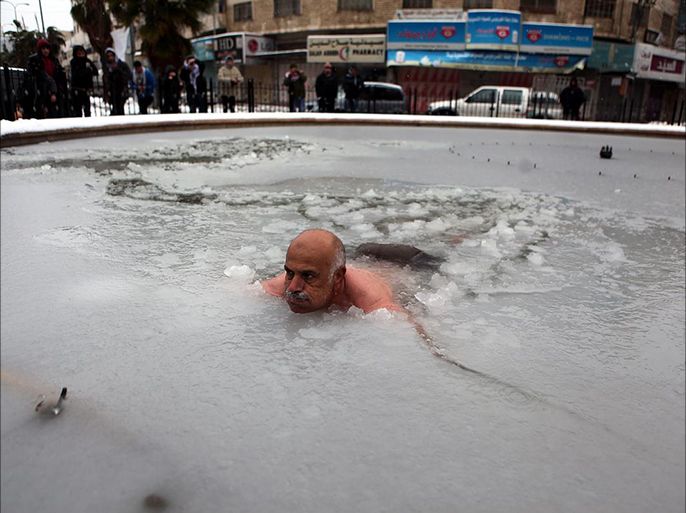 فلسطيني يسبح في الثلج تضامنا مع غزة وسوريا