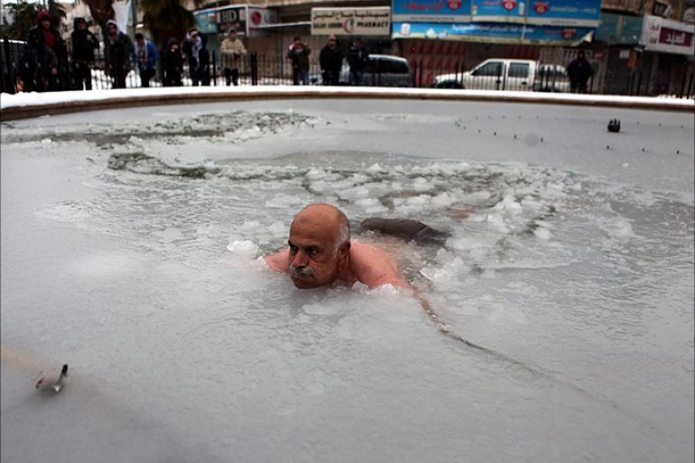 فلسطيني يسبح في الثلج تضامنا مع غزة وسوريا