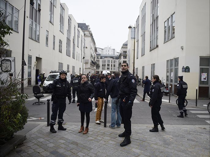 Police forces gather in street outside the offices of the French satirical newspaper Charlie Hebdo in Paris on January 7, 2015, after armed gunmen stormed the offices leaving at least 10 people dead according to prosecutors. AFP PHOTO / MARTIN BUREAU